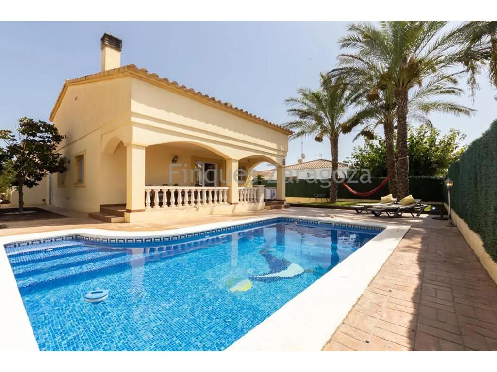 Beautiful villa in the urbanisation of Riumar, 4 minutes walk from the promenade and 10 minutes from the river port.The villa is built on a plot of 300m², inside of which there is a swimming pool for private use. The villa has 77m² constructed area, plus 28m² belonging to the store room, plus 37m² of attic.On the ground floor we find the living/dining room/kitchen with fireplace, 3 double bedrooms with fitted wardrobes and 2 bathrooms. The master bedroom is en-suite (with private bathroom).From the dining room there is access to the terrace with porch and from here there is direct access to the swimming pool.On the outside and at the back of the house there is a staircase to access the terrace on the first floor and the attic.The villa has a garage for private use.It is equipped with double glazed aluminium windows and air conditioning with heat pump in all rooms.