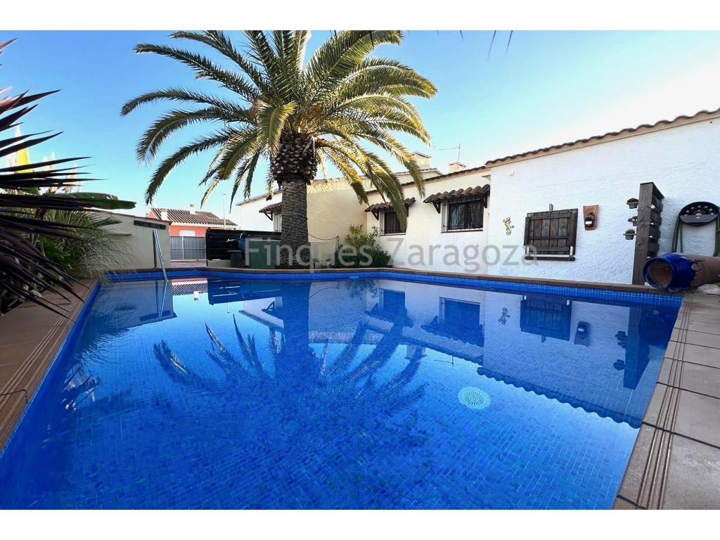 Se vende chalet en Riumar, a pocos minutos de la playa, ideal para disfrutar de la tranquilidad y el clima mediterráneo. Con una superficie de 80 m², esta vivienda ofrece un ambiente acogedor y confortable, perfecto tanto para vivir todo el año como para segunda residencia.El chalet dispone de dos habitaciones dobles y una habitación individual, que actualmente está destinada a despacho. Cuenta con un baño reformado con plato de ducha, una cocina funcional, un salón-comedor luminoso y una amplia terraza donde relajarse al aire libre.En el exterior, destaca su piscina privada, situada en la parte posterior de la casa, en la zona más tranquila y alejada de la calle, lo que proporciona mayor privacidad. La vivienda también cuenta con un bonito jardín con árboles, plantas y una zona de barbacoa, ideal para disfrutar con familia y amigos. Además, dispone de un almacén de 25 m², proporcionando un espacio extra para almacenamiento.Características principales: • 80 m² de vivienda • Dos habitaciones dobles y una habitación individual (actualmente despacho) • Baño reformado con plato de ducha • Cocina equipada • Salón-comedor con luz natural • Terraza espaciosa • Piscina privada en la parte posterior de la casa, en la zona más tranquila • Jardín con árboles, plantas y barbacoa • Almacén de 25 m² • Ubicación en Riumar, cerca de la playaUna vivienda ideal para quienes buscan comodidad y proximidad al mar.Para más información o para concertar una visita, contacte con nosotros.